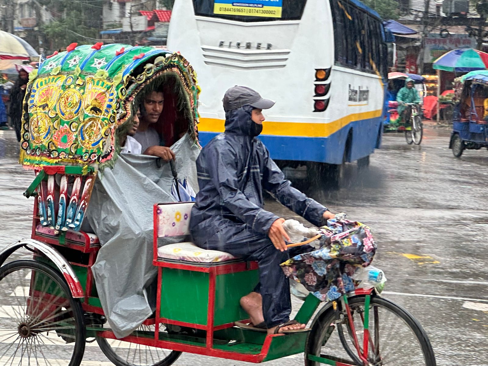 বৃষ্টির মধ্যে যাত্রী নিয়ে গৌন্তব্যে যাচ্ছেন রিকশা চালক। ছবি- সাইফুল ইসলাম